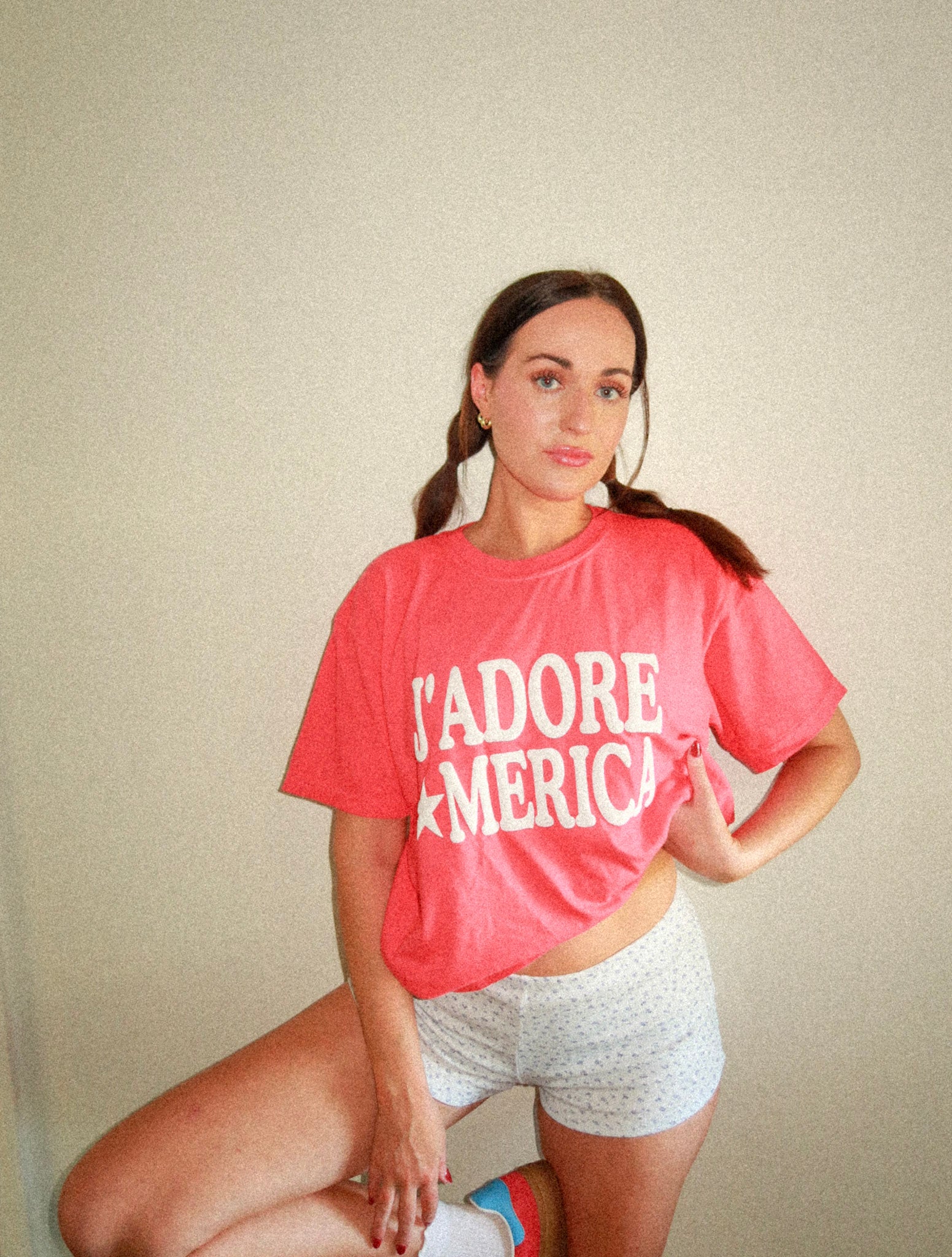 Model wearing shirt with one hand on hip, showing full front design